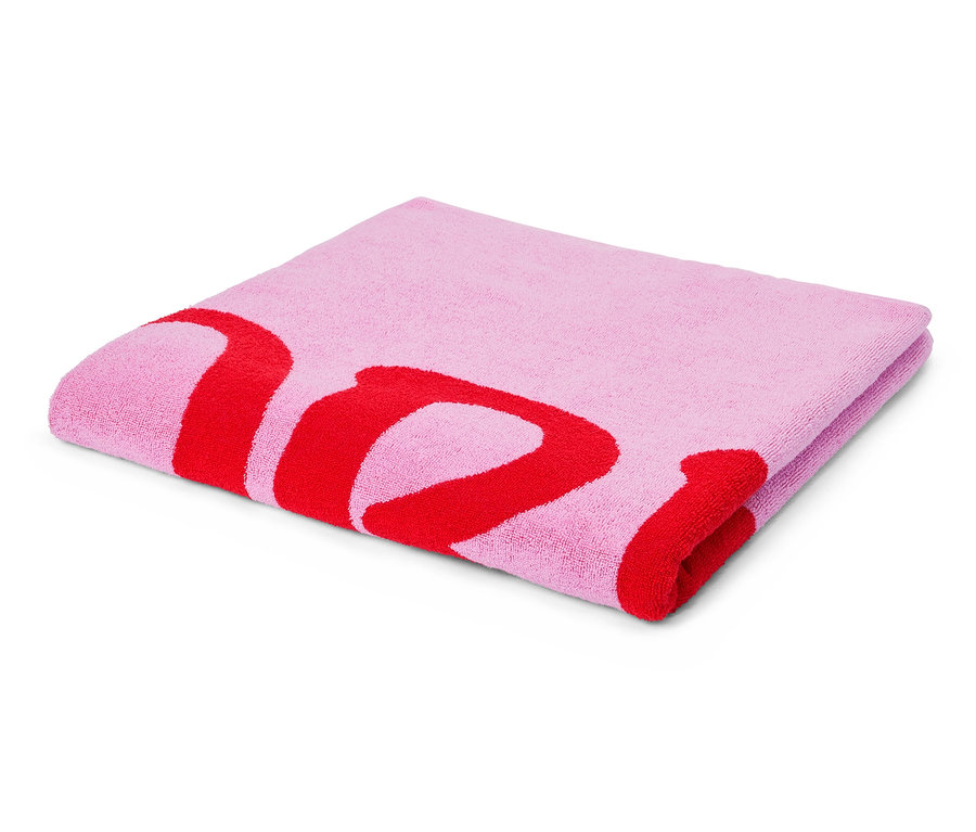 Ein gefaltetes, hellrosa Handtuch mit einem roten Buchstabenaufdruck liegt auf einem weißen Hintergrund.