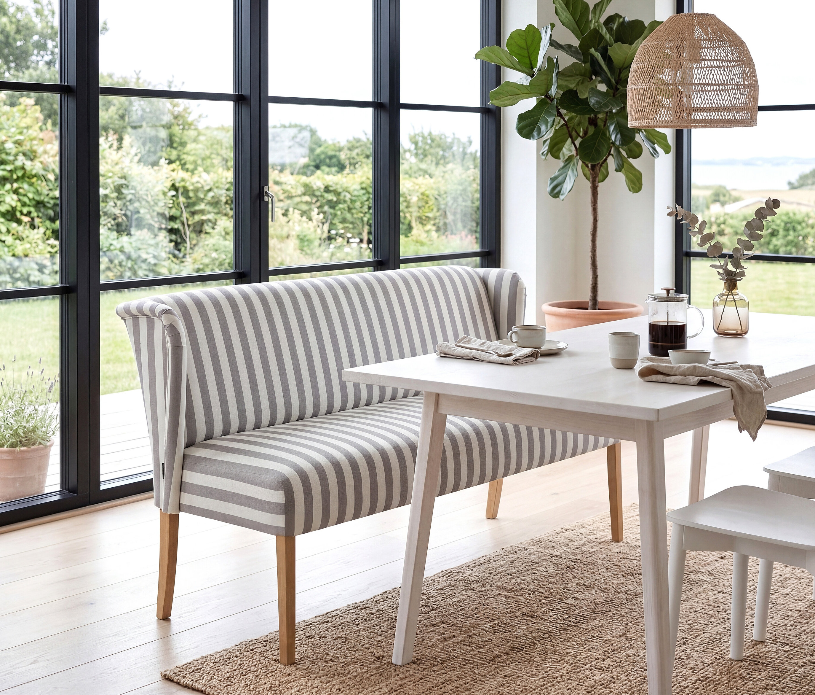 Gestreifte »Hendrick« Polsterbank steht am Esstisch mit Kaffeegeschirr vor Fenster mit Gartenblick.