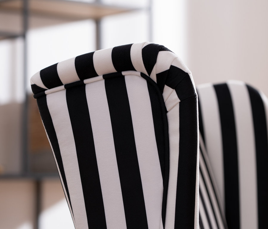 Detailansicht eines schwarz-weiß gestreiften »Hendrick« Hochlehner-Polsterstuhls mit Armlehne.
