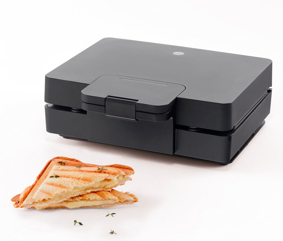 Schwarzer WILFA Sandwichtoaster und zwei Sandwiches auf weißem Hintergrund.