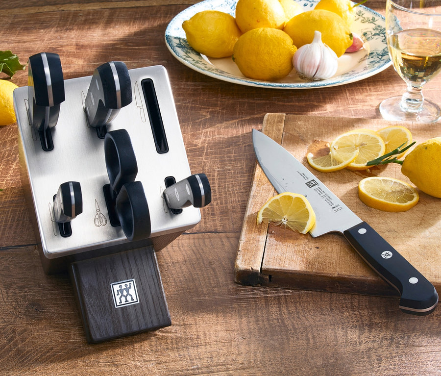 ZWILLING Selbstschärfender Messerblock »Gourmet« und Zitronen auf einem Holztisch.