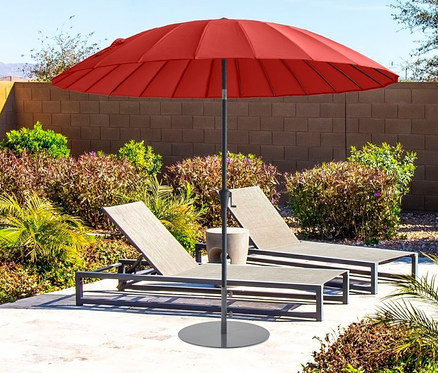 Ein roter Leco Shanghai Sonnenschirm mit einem Durchmesser von 270 cm steht zwischen zwei Liegestühlen auf einer Terrasse.