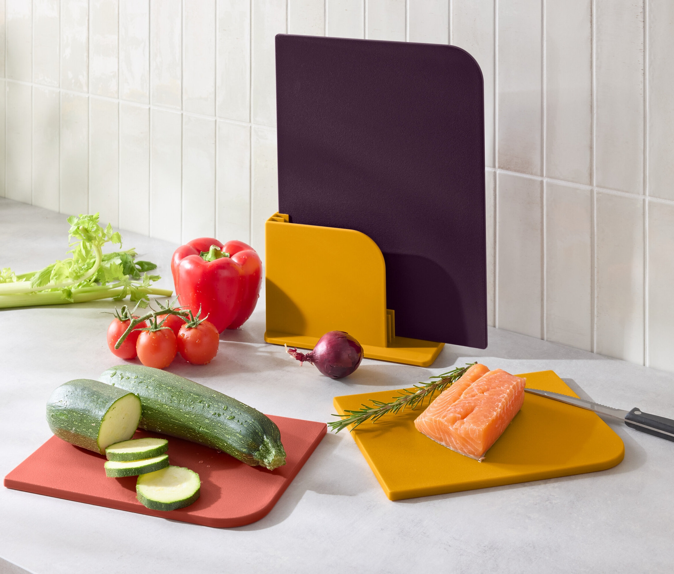 Gemüse und Lachs auf bunten Schneidebrettern.