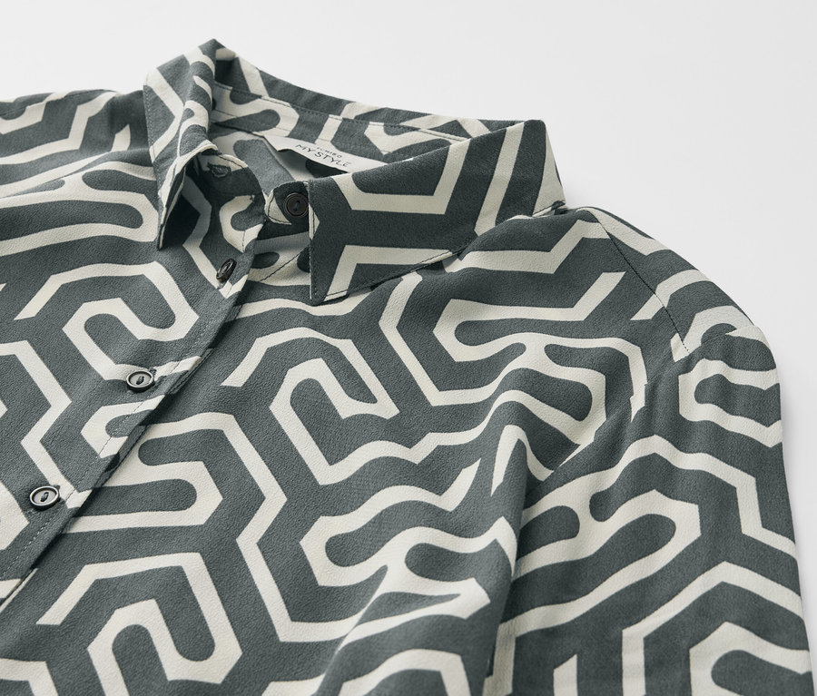 Detailansicht eines bedruckten Hemdblusenkleids mit geometrischem Muster.