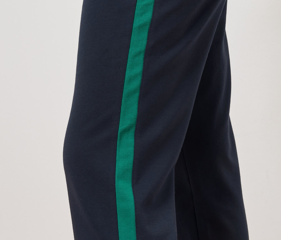 Detail einer Hose mit marineblauem Hintergrund und einem grünen Streifen an der Seite.