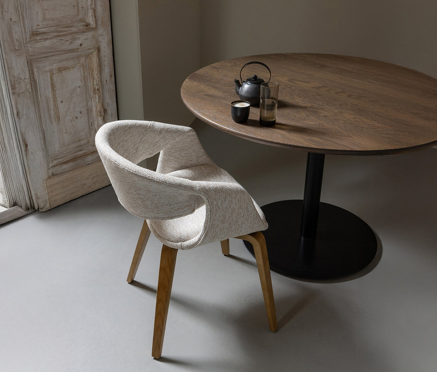 Ein einzelner naturfarbener WOOOD Esszimmerstuhl »Yossi« mit Holzfuß steht neben einem runden Holztisch mit Teekanne und zwei Gläsern.
