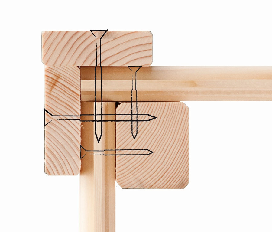 Detail einer Holzkonstruktion, die mit Nägeln verbunden ist.