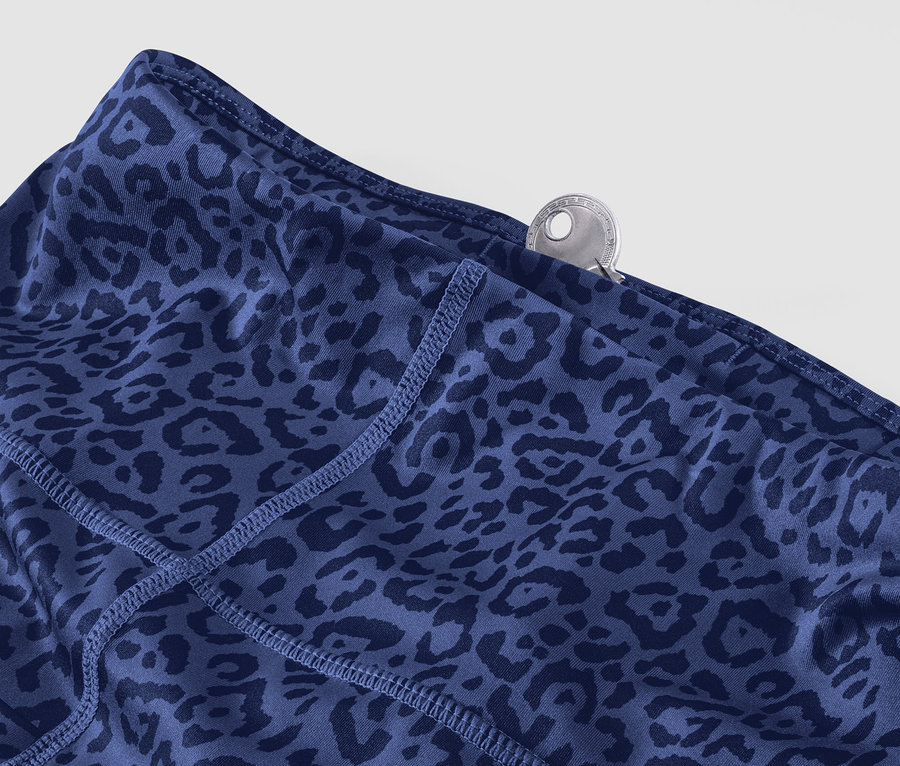 Detail einer lila Sporttight. In der Tasche steckt ein Schlüssel.