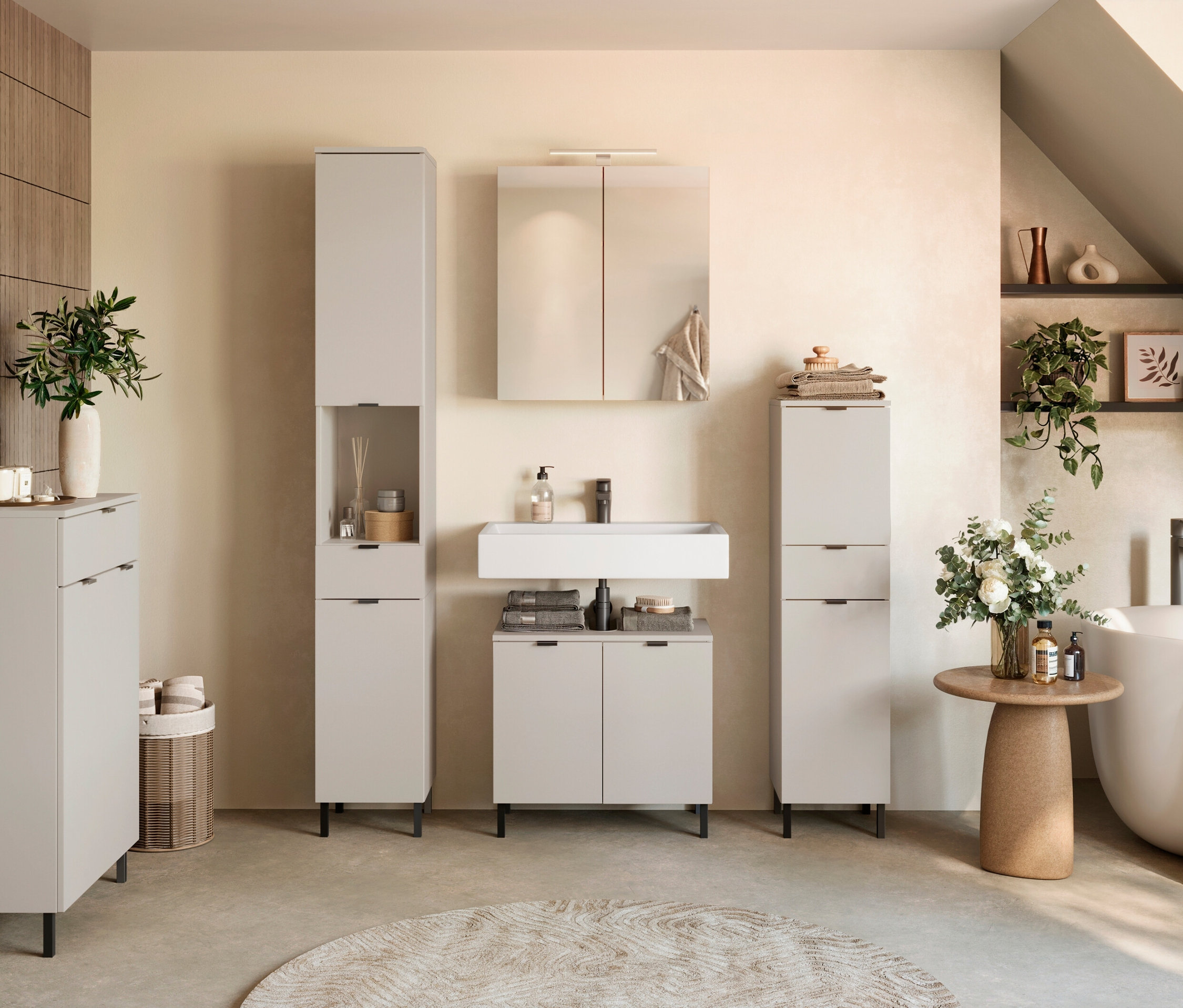 Badezimmer-Interieur mit Waschtisch, Spiegelschrank, Hochschränken und Badewanne.