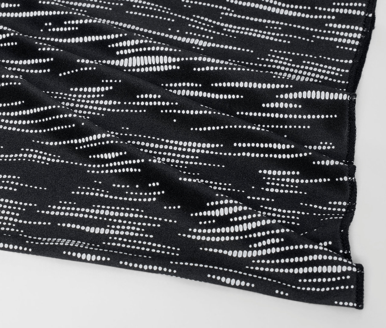 Detailaufnahme eines schwarzen Stoffbezugs mit weißem Punktmuster.