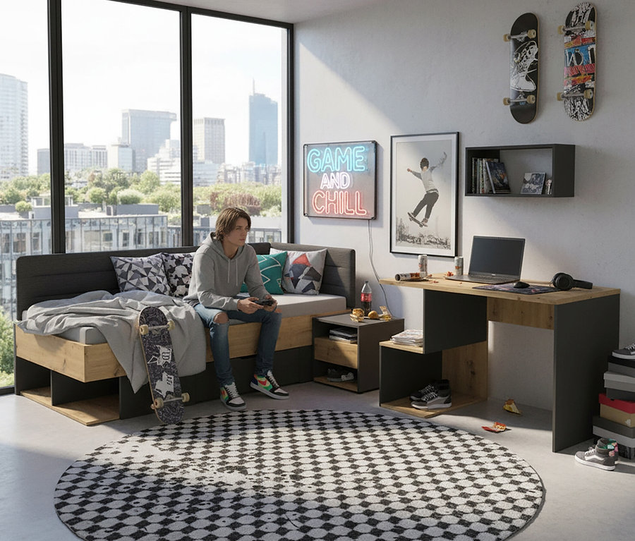 Jugendlicher sitzt mit Gamecontroller auf einem Bett mit einem Skateboard daneben, im Hintergrund der Roba Schreibtisch »Marvin«.