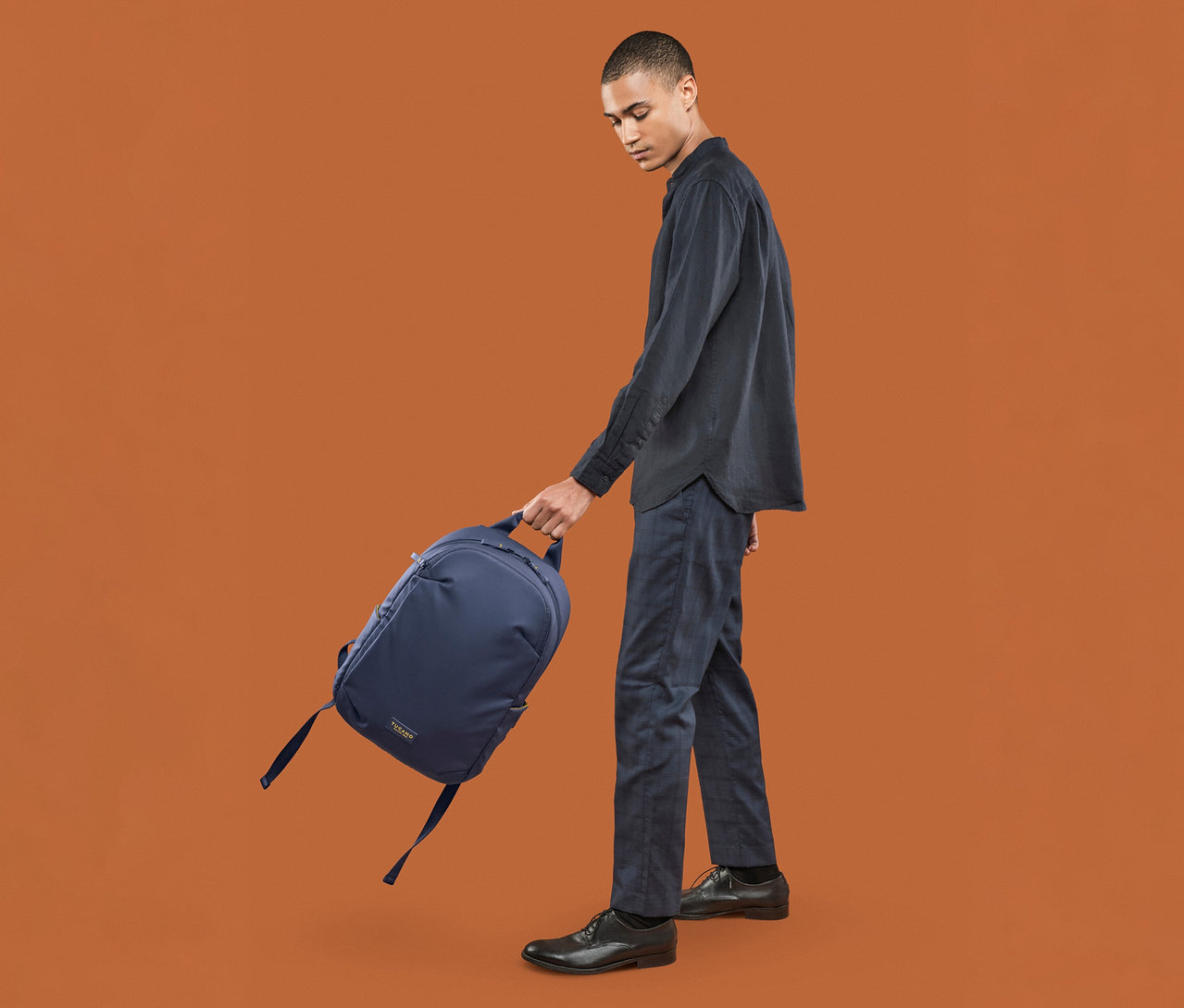 Mann hält einen blauen Tucano LASER Rucksack, Laptop 15,6".