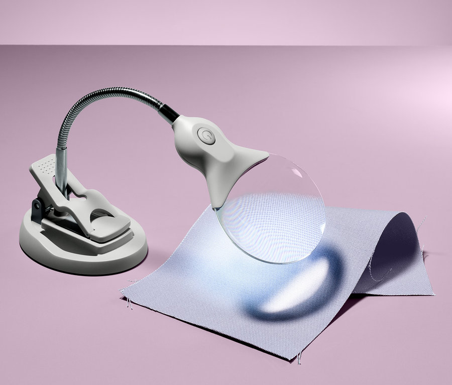 Eine Arbeitslupe mit LED-Beleuchtung liegt auf einem Blatt Papier.