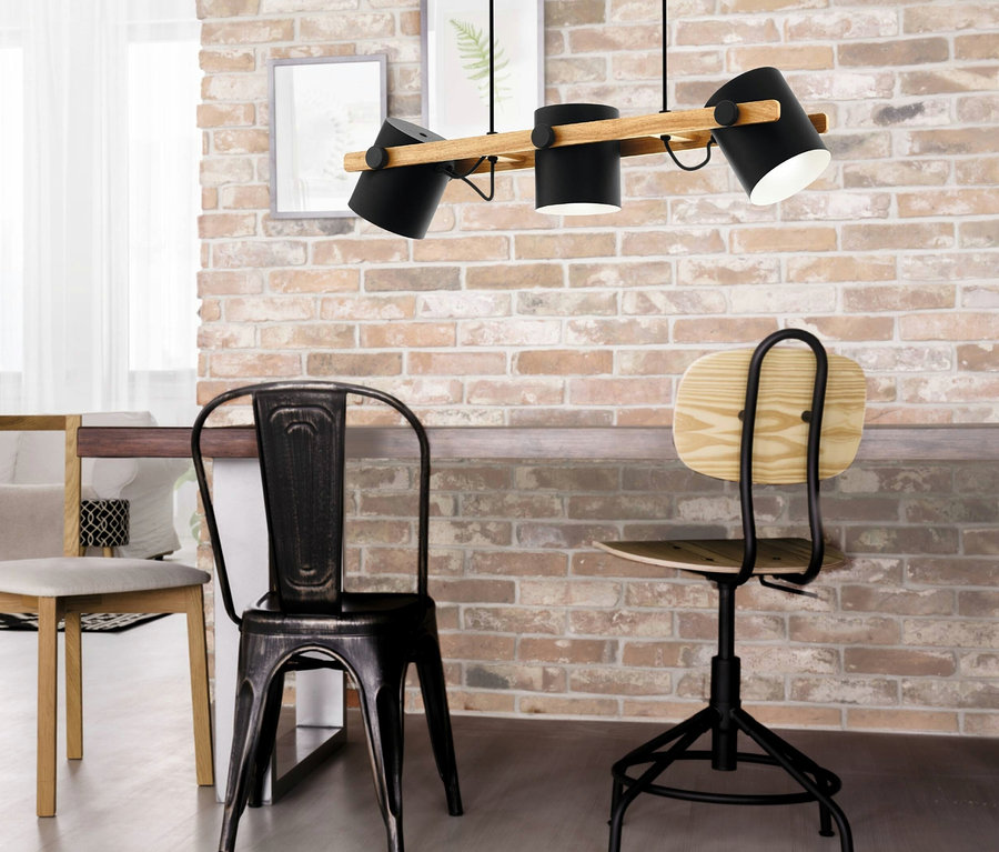 Schwarze Eglo 3er-Pendelleuchte »Hornwood« über drei Stühlen.