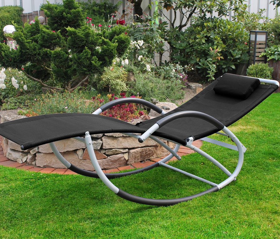 Eine anthrazitfarbene Schaukelliege mit verstellbarer Rueckenlehne steht auf einer Wiese.