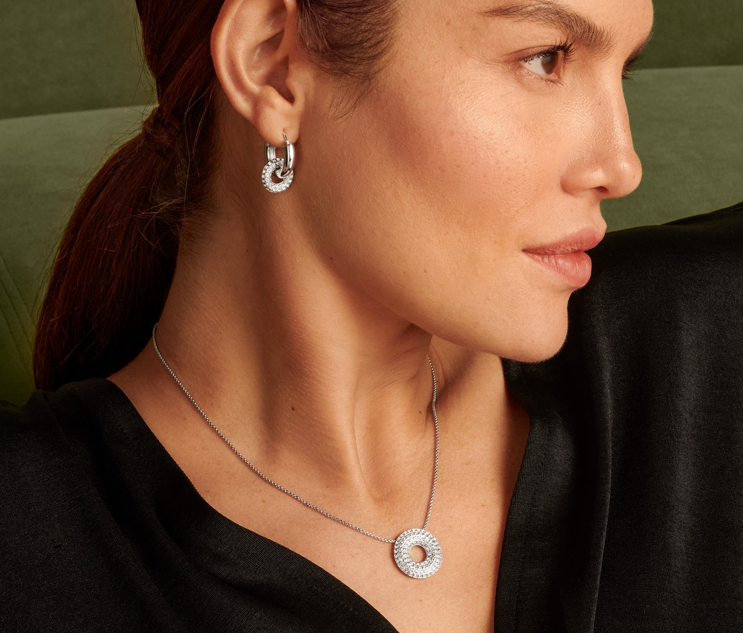 Profil einer Frau mit Kette Sparkle Donut und Ohrringen.