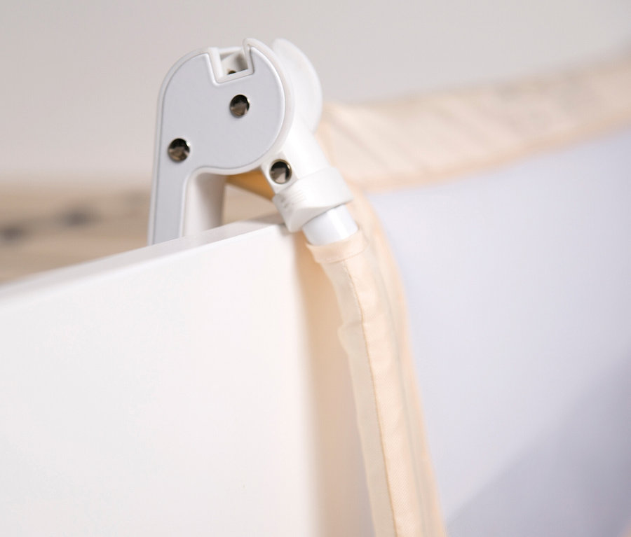 Detail einer Ecke eines weißen Kinderbetts mit beigem roba Bettschutzgitter »Klipp-Klapp«.