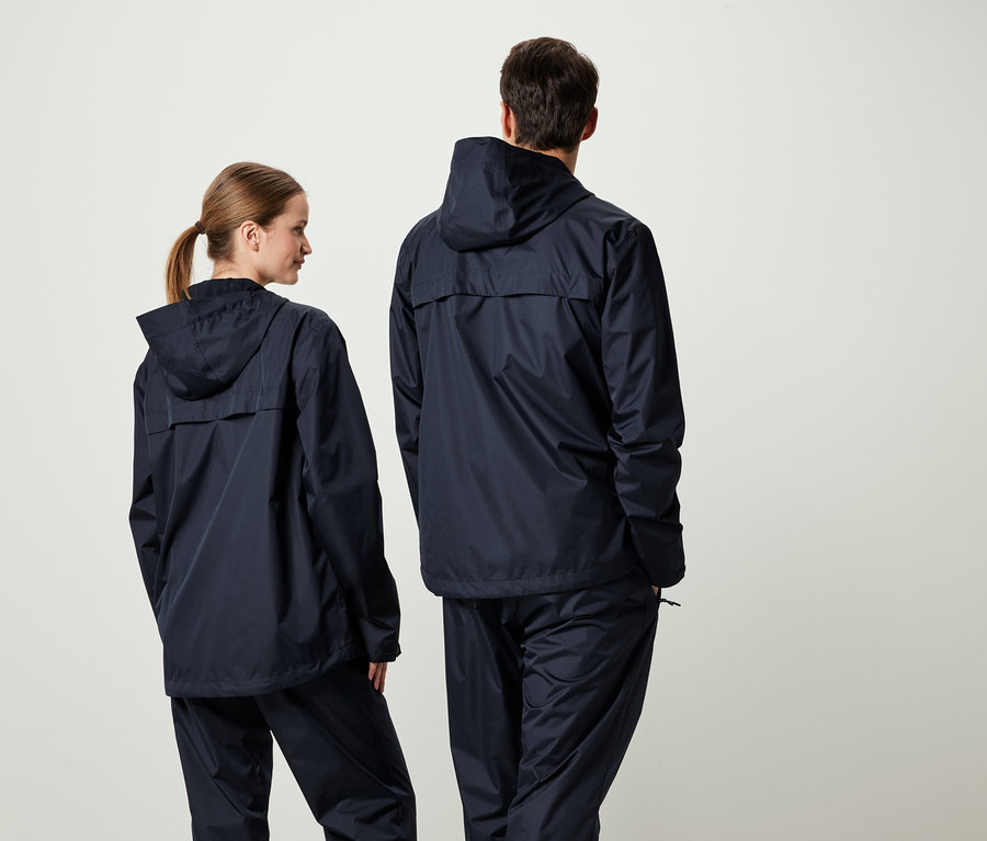 Zwei Personen mit dem Rücken zur Kamera in passenden dunkelblauen Kapuzenjacken und Hosen.