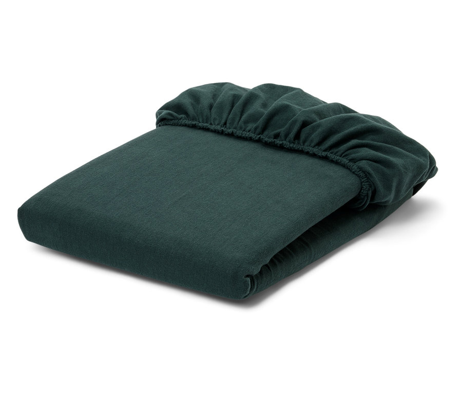 Gefaltetes grünes Spannbetttuch auf weißem Hintergrund.