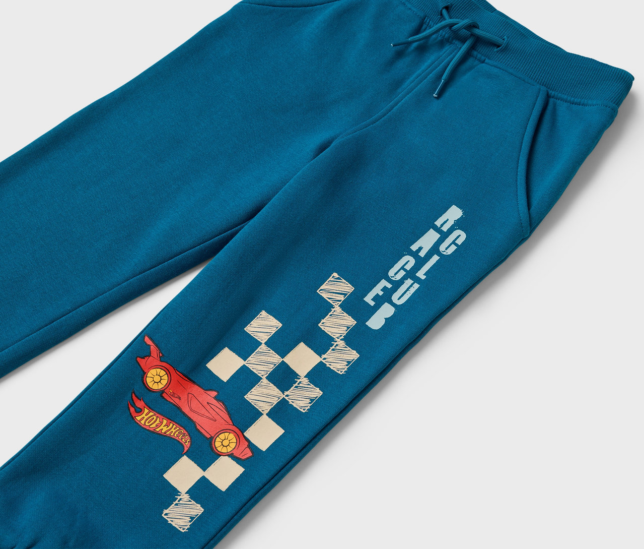 Blaue Trainingshose mit rotem Auto und Schachbrettmuster.