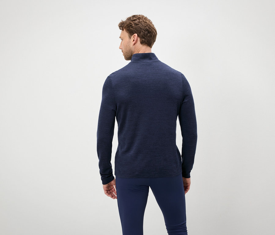 Mann von hinten trägt einen blauen Pullover und Hose.
