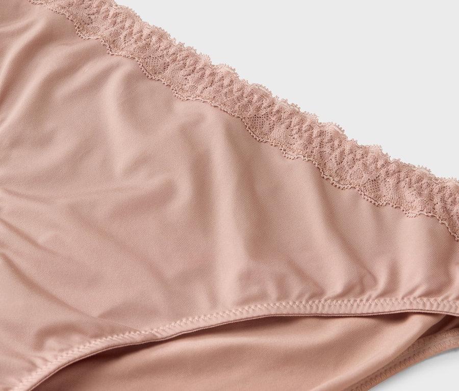 Nahaufnahme eines hellrosa Slips mit Spitze am Bund.