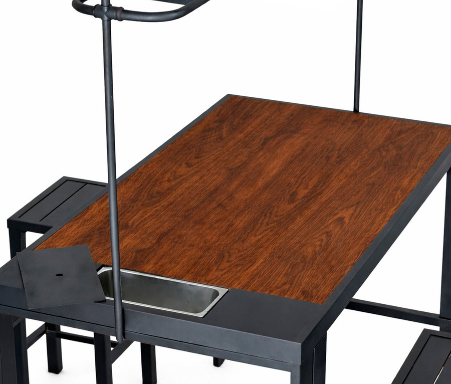 Nahaufnahme des Leco Bartischs mit vier Hockern, der eine Holzplatte, eine Spüle und eine schwarze Metallstruktur aufweist.