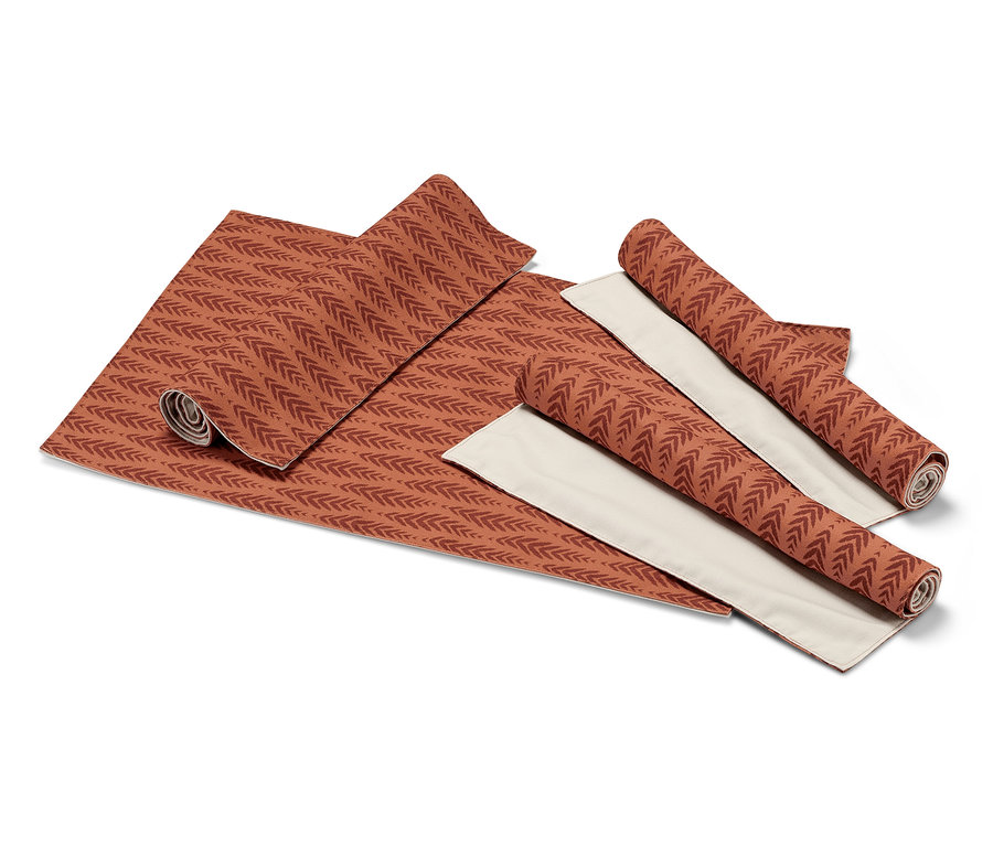 Ausgebreitete und gerollte 4 Wende-Platzsets mit Terrakotta-Blattmuster auf beigem Hintergrund.