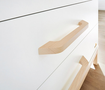 Detailaufnahme eines weißen, 3-teiligen Pinolino Sets "Light" mit Holzgriffen; gelbe Gummistiefel im Hintergrund.