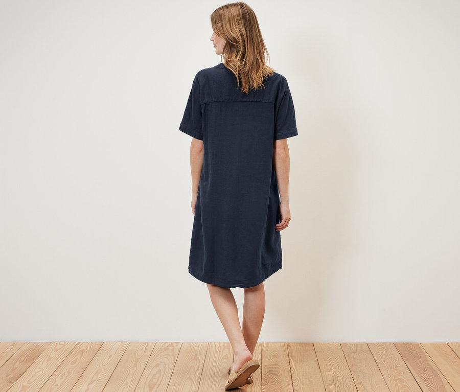 Frau von hinten in einem Leinenkleid.