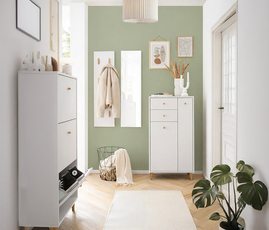 Flur mit Schuhschrank, Garderobe, Spiegel und Dekorationen an einer mintgrünen Wand.
