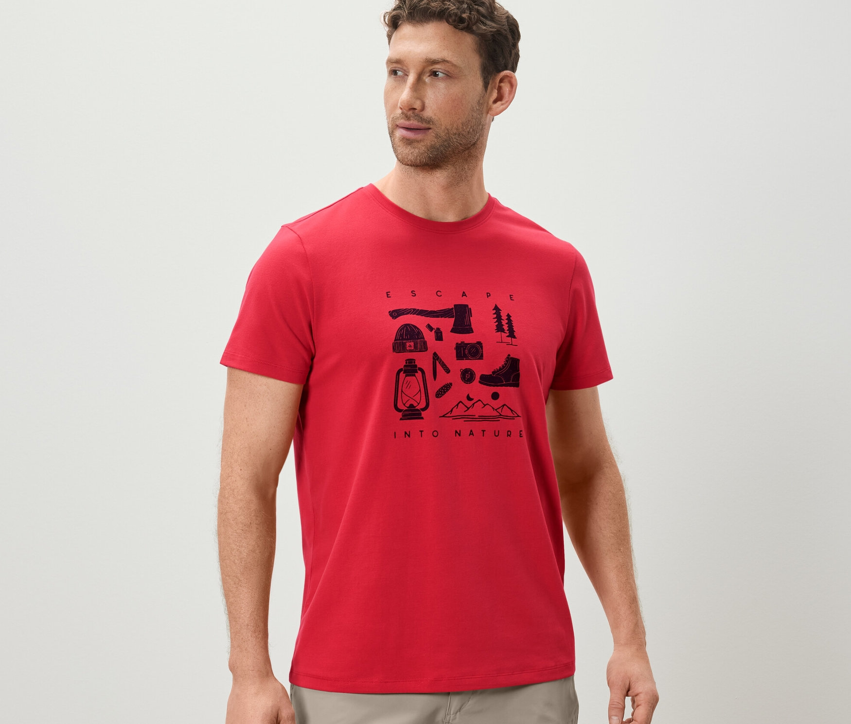 Mann trägt ein rotes T-Shirt mit Camping-Print.