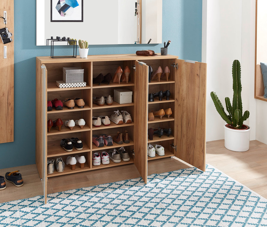 Offener 3-türiger Schuhschrank »Telde« voll mit Schuhen auf einem blau-weißen Teppich.