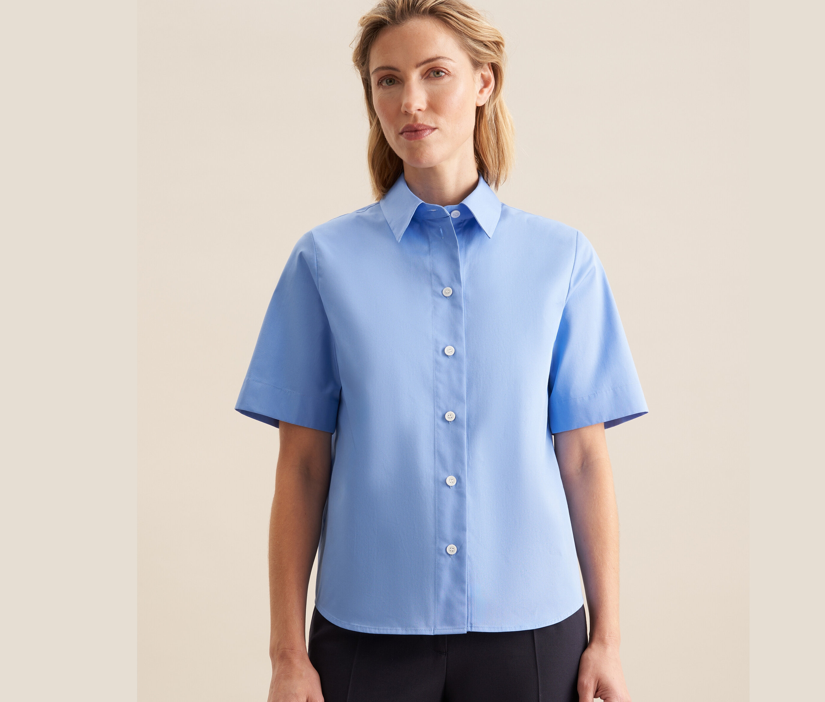 Frau trägt eine hellblaue Seidensticker Kurzarm-Bluse.