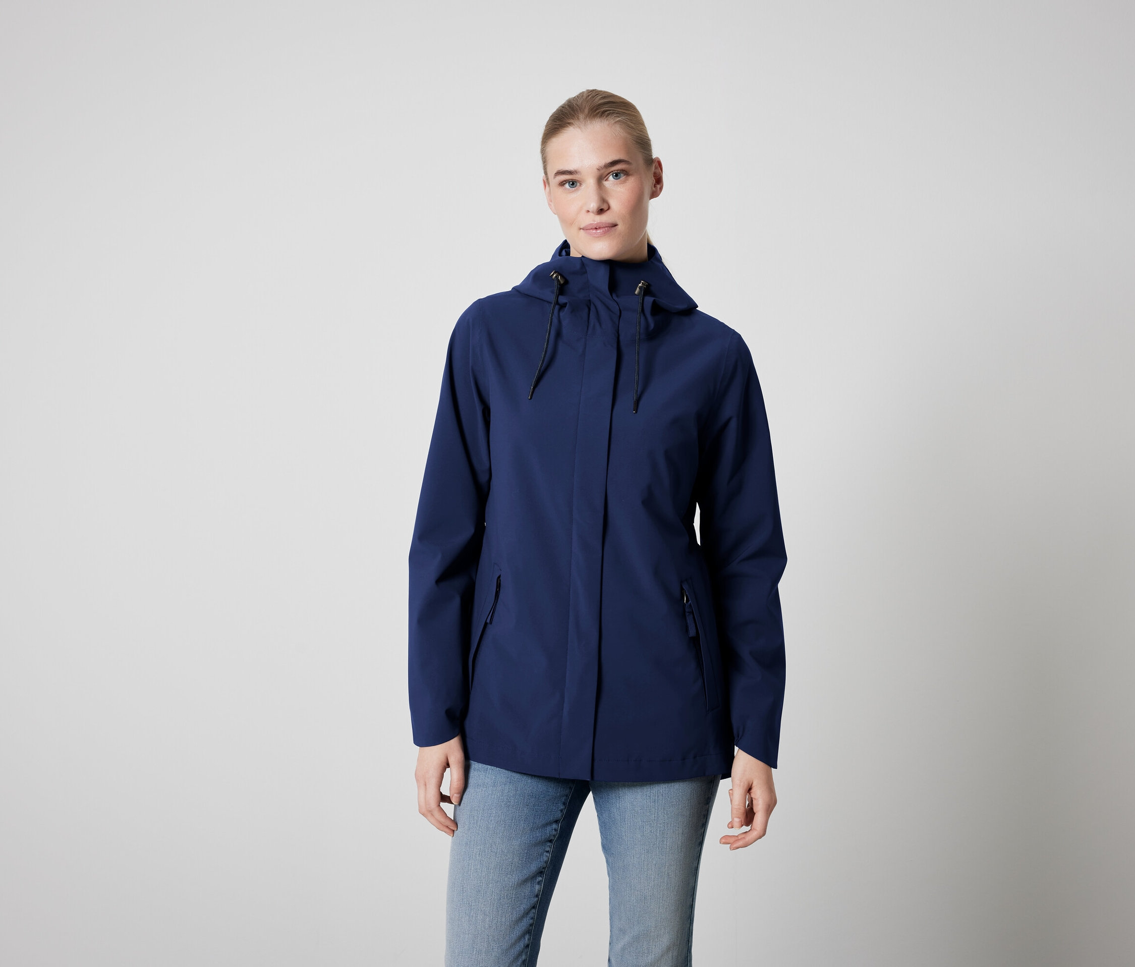 Frau trägt eine blaue Jacke und Jeans.