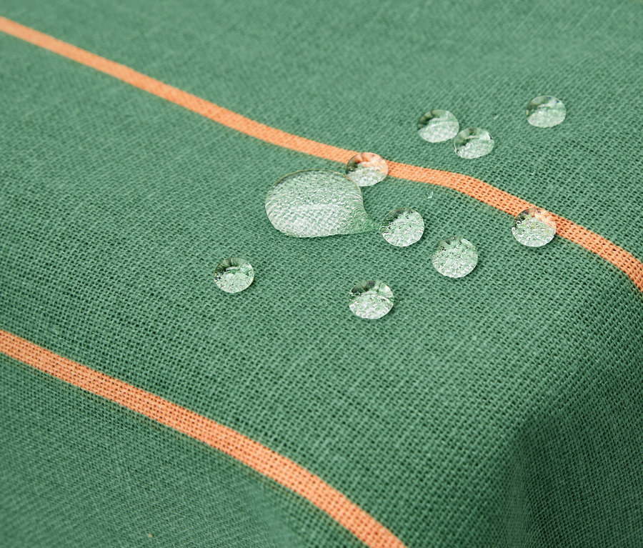 Detail einer abwischbaren Tischdecke, ca. 90 x 90 cm, gestreift mit Wassertropfen.