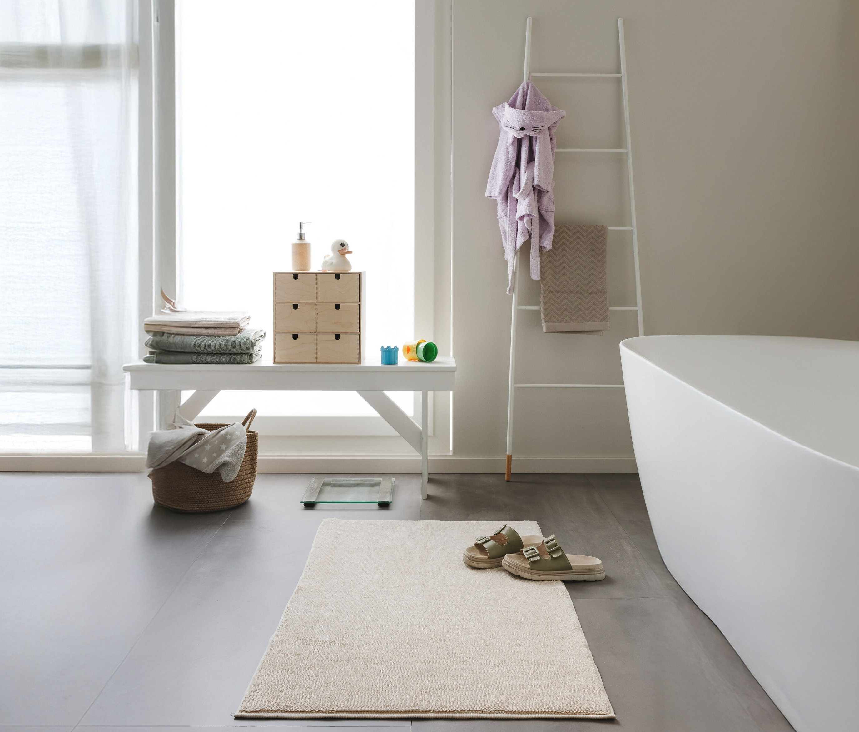 Eine beige Badematte »Ole« von benuta (70 x 120 cm) liegt im Badezimmer.