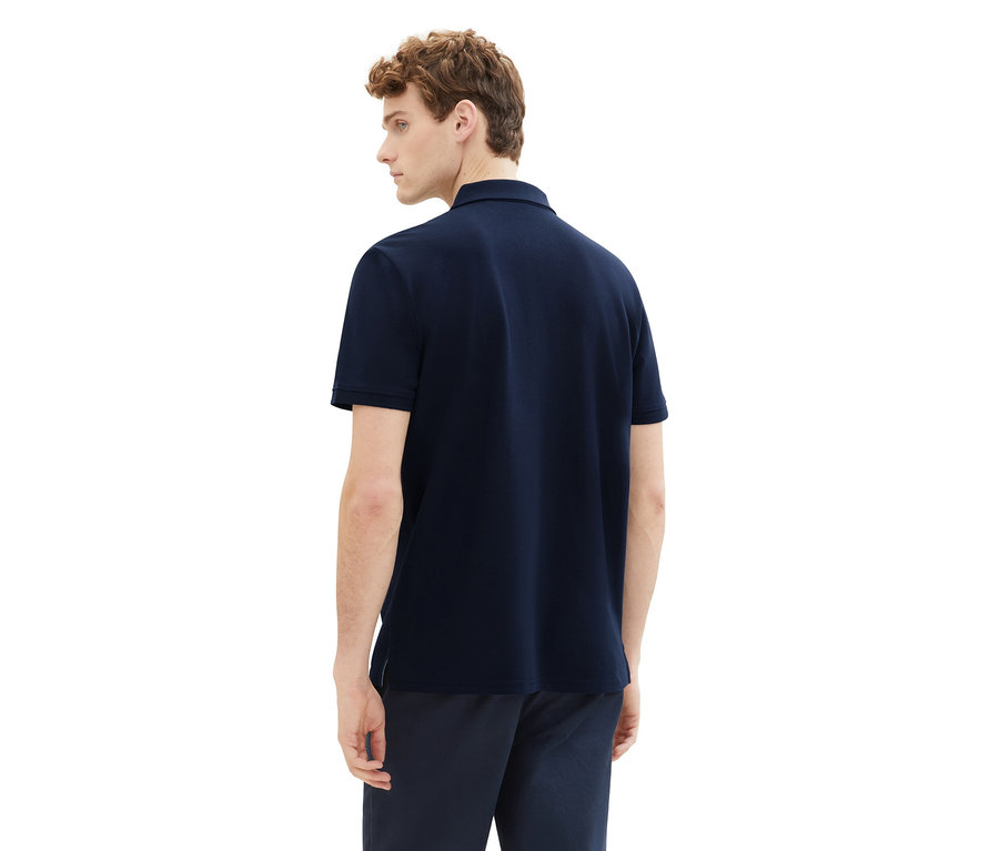 Mann von hinten, trägt ein Tom Tailor Piqué Poloshirt in Sky Captain Blue und dunkle Hose.