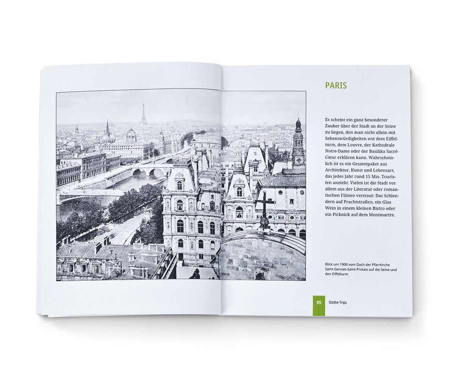 Offenes Buch mit Schwarzweißfotografie von Paris. Buch »Landkarten Rätselbuch«.