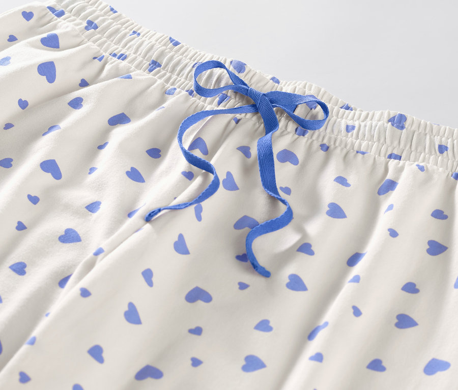 Detail einer Pyjamahose mit Herzen und blauem Kordelzug.