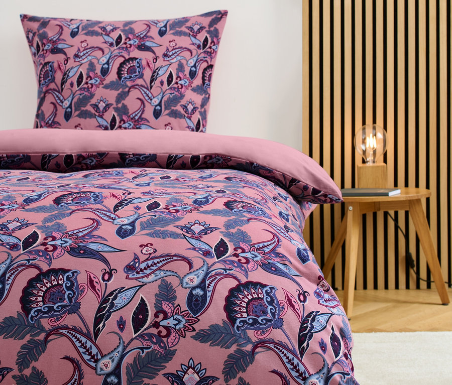 Winterjersey-Bettwäsche Normalgröße mit Blumenmuster auf einem Bett.