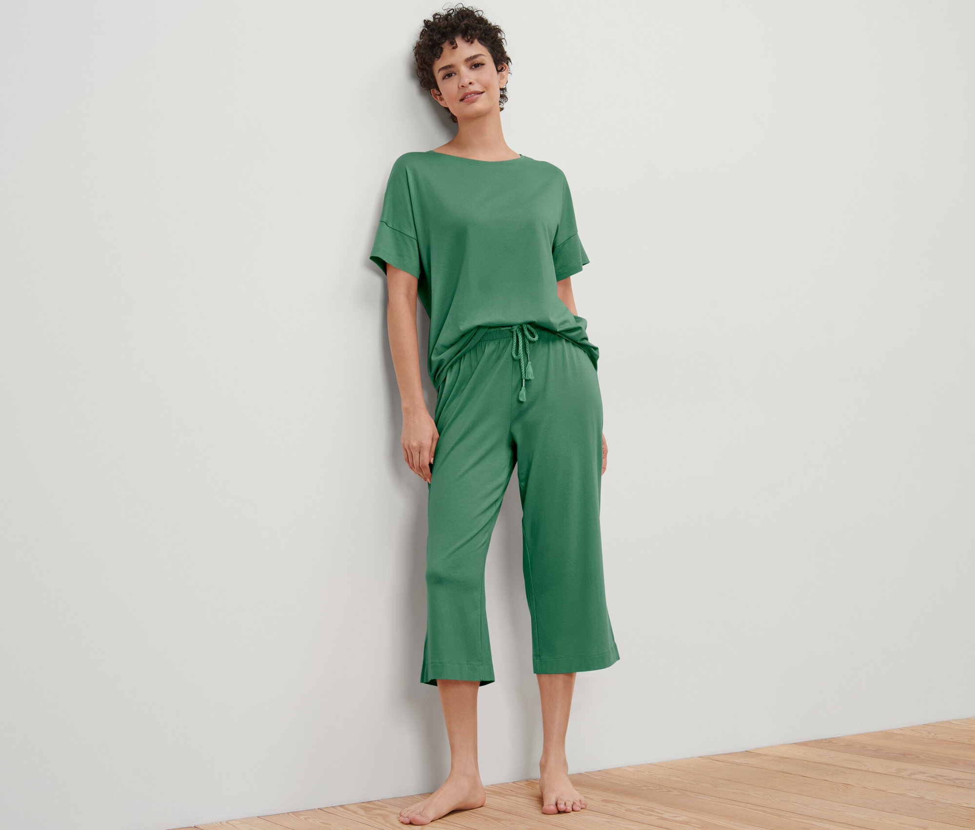 Frau posiert in grünem 3/4-Pyjama-Set.