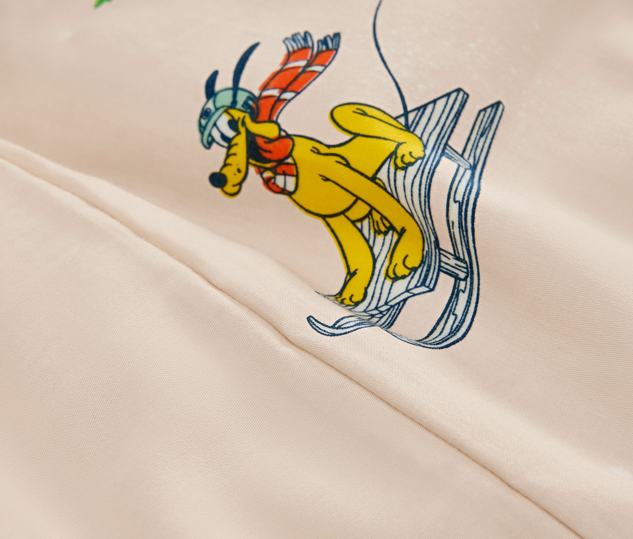 Cartoon-Bild eines gelben Hundes mit Helm und Schal auf Skiern auf beigem Hintergrund.