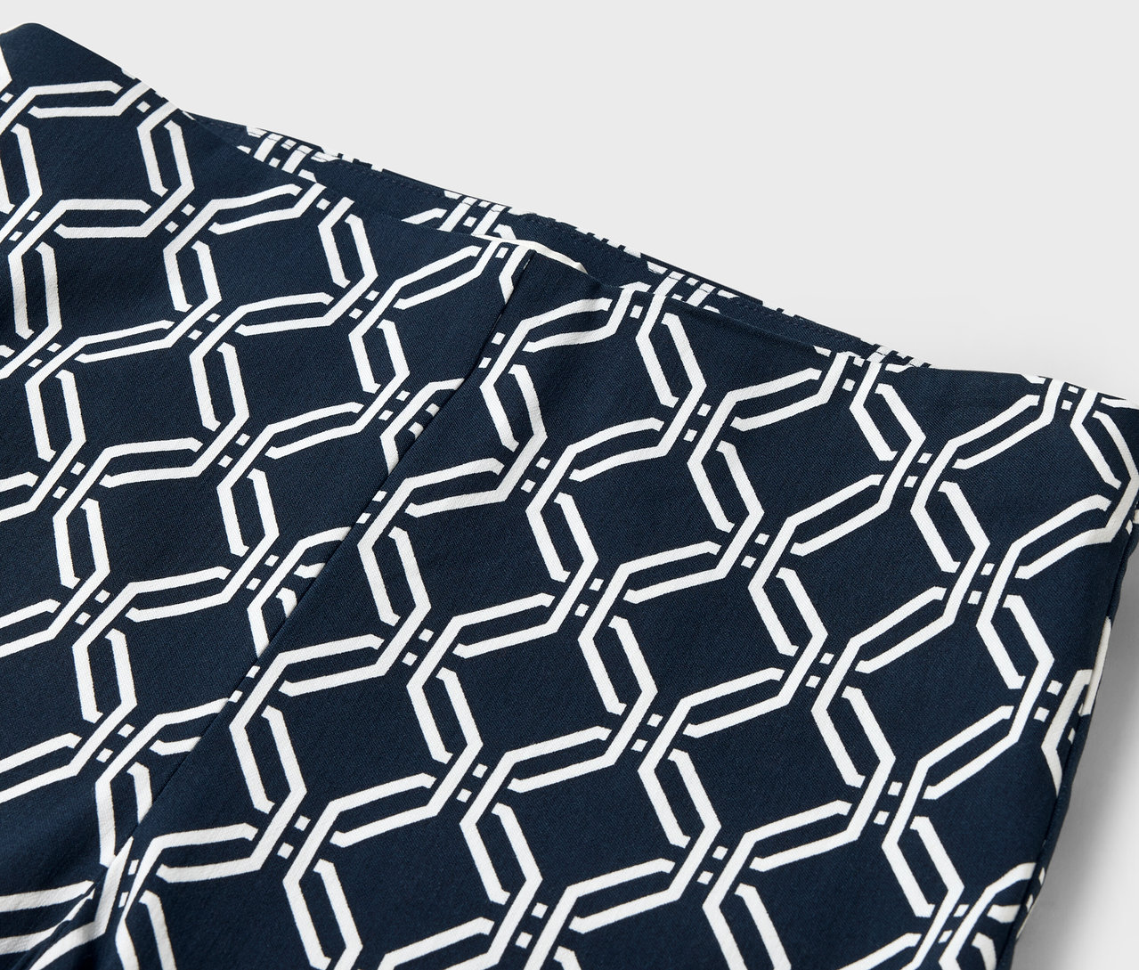 Detailaufnahme einer marineblauen Leggings mit weißem, geometrischem Muster.