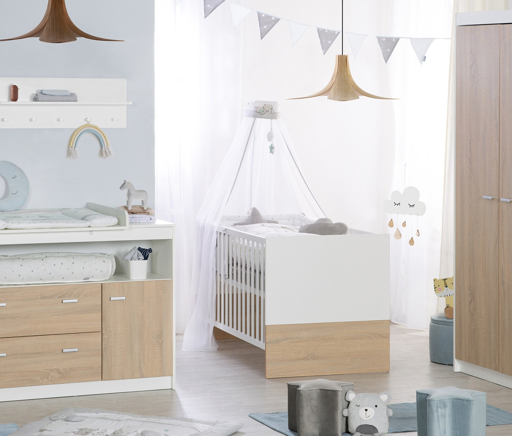 Ein Kinderzimmer mit einem Bett, einer breiten Wickelkommode und einem dreitürigen Schrank.