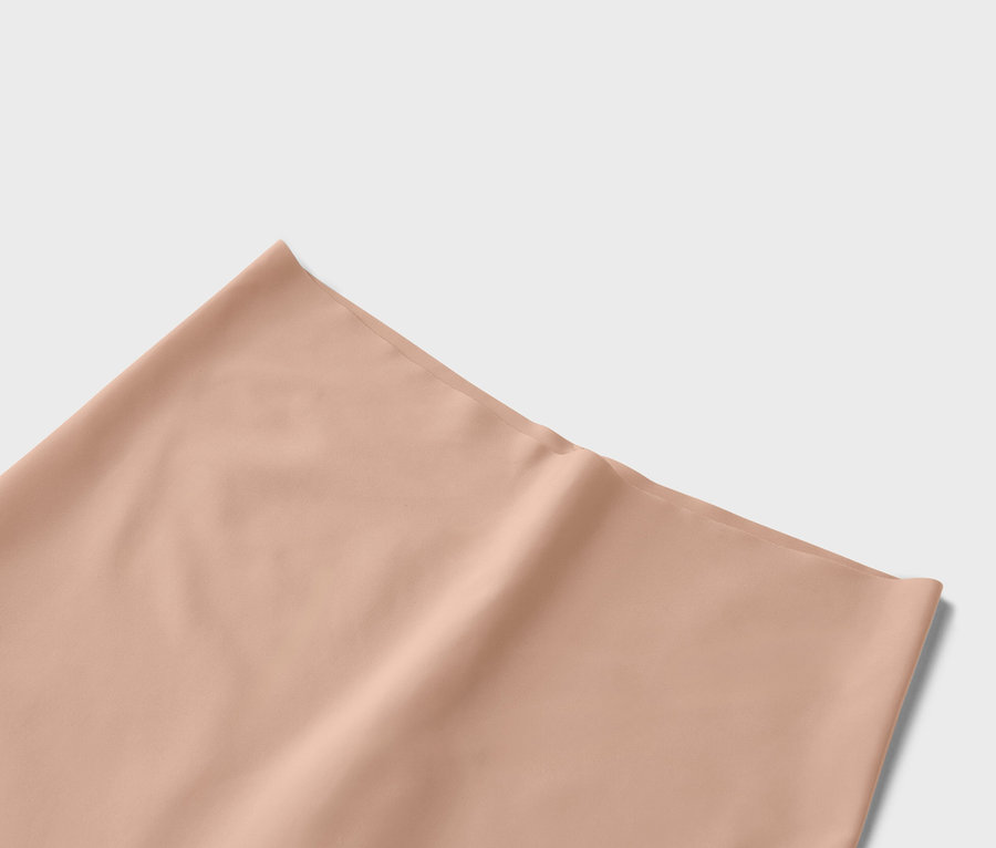 Nahaufnahme eines einfarbigen Stoffes in Pfirsichfarbe.