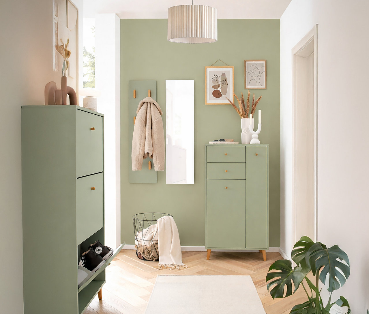 Flur mit hellgrünen Möbeln, darunter ein Schuhschrank, ein Schrank mit Schubladen und eine Garderobe mit Spiegel.