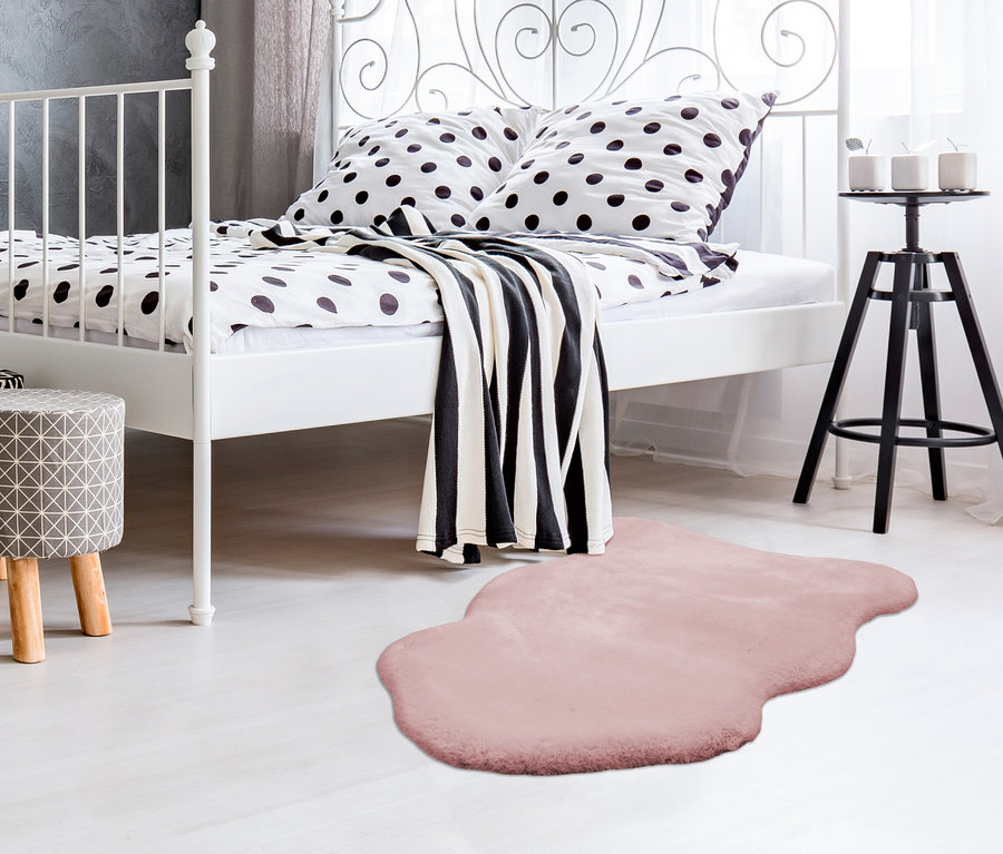 Weißes Metallbettgestell mit schwarz-weißer Bettwäsche und Kayoom Deko-Kunstfell »Rabbit Sheepskin 200«.