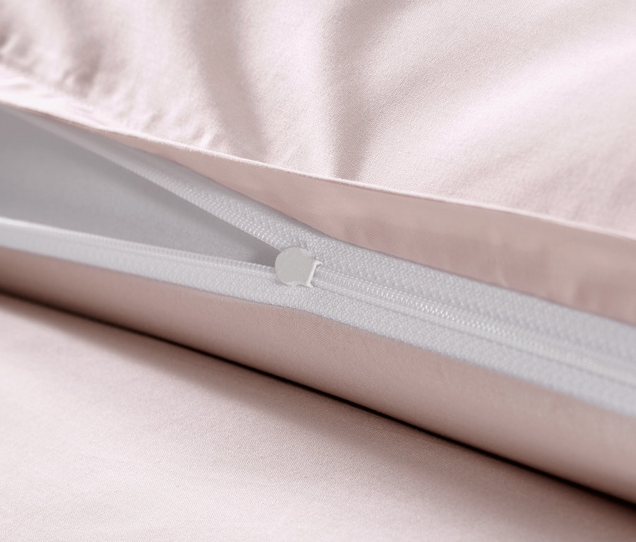 Detailansicht von rosafarbener Baumwollsatin-Bettwäsche mit Reißverschluss.