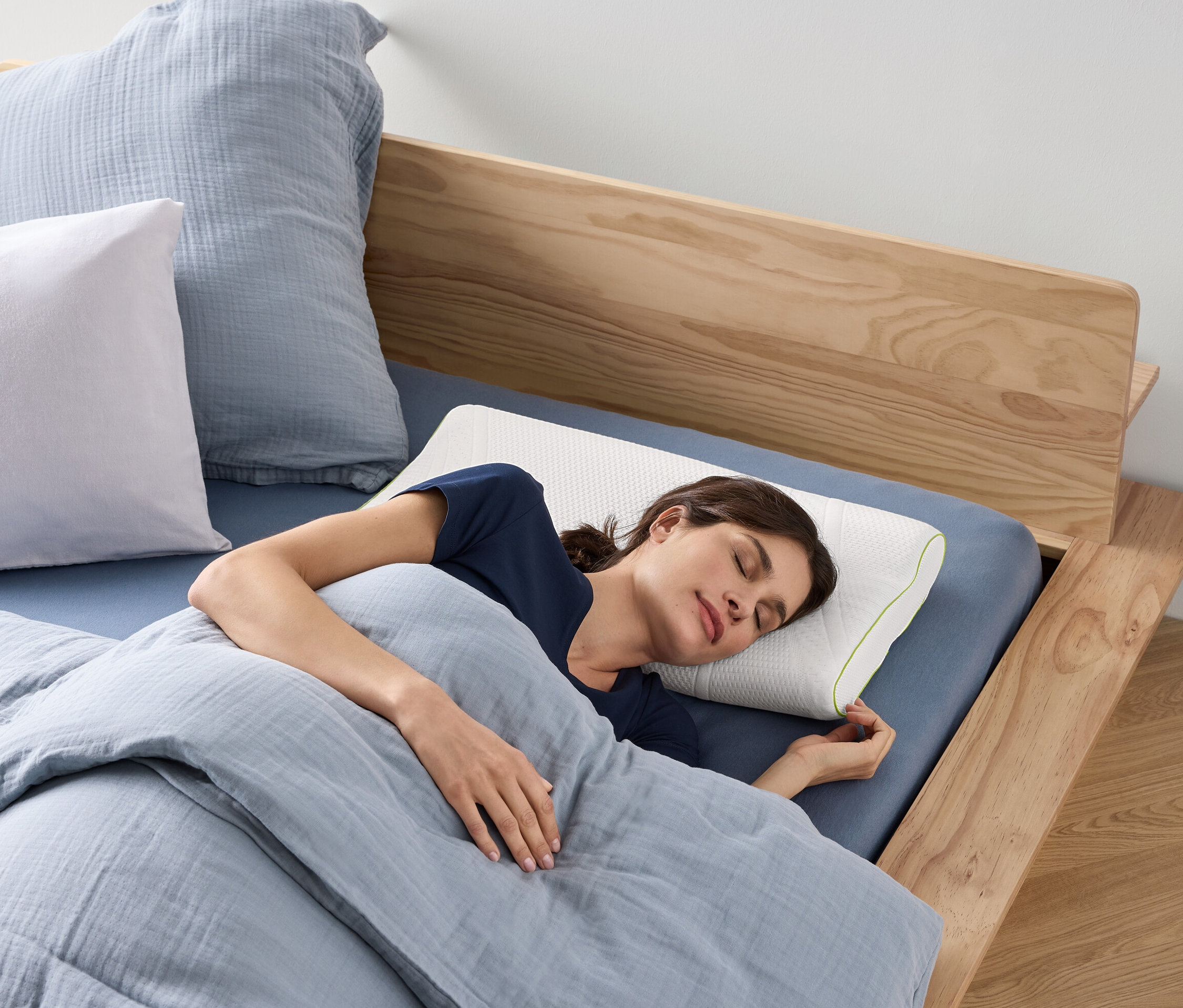 Frau schläft auf einem irisette® greenline Nackenstützkissen auf einem Bett.